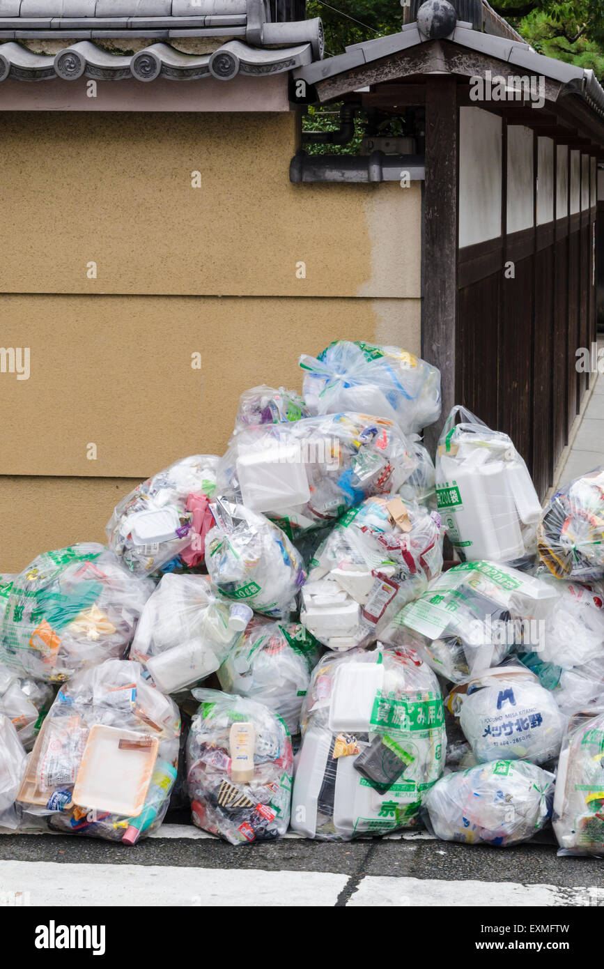 https://c8.alamy.com/comp/EXMFTW/plastic-bags-filled-with-rubbish-on-a-street-corner-of-kyoto-kansai-EXMFTW.jpg