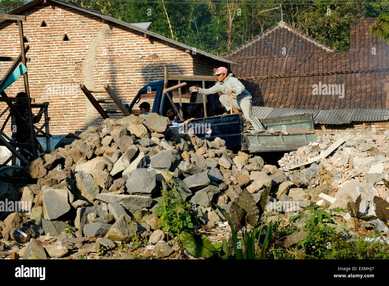 local workers dump rubble from the back of a truck onto waste ground in