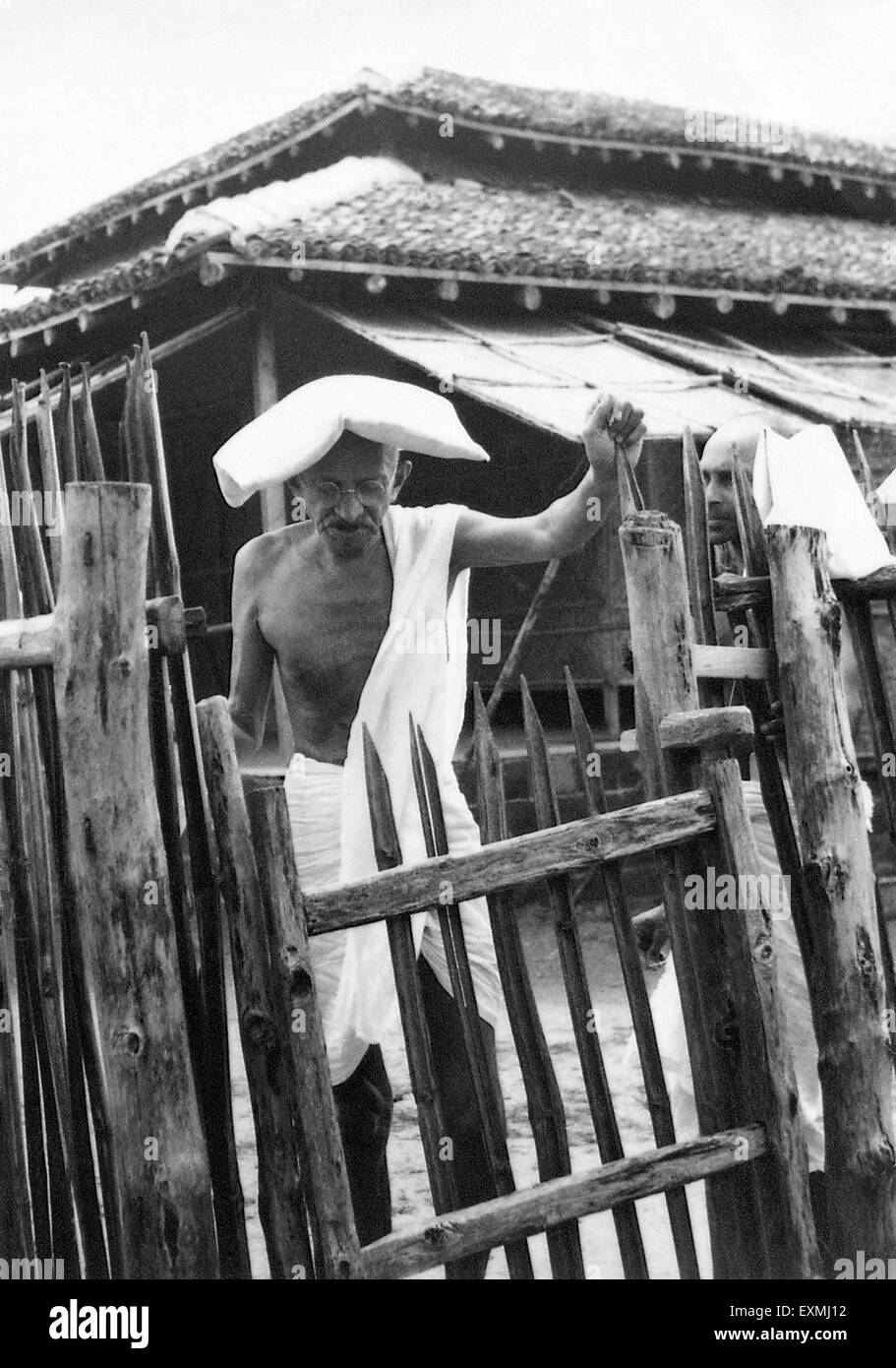 Mahatma Gandhi ; carrying a pillow on his head due to severe heat ; in front of the office hut at Sevagram Ashram ; 1940 NO MR Stock Photo