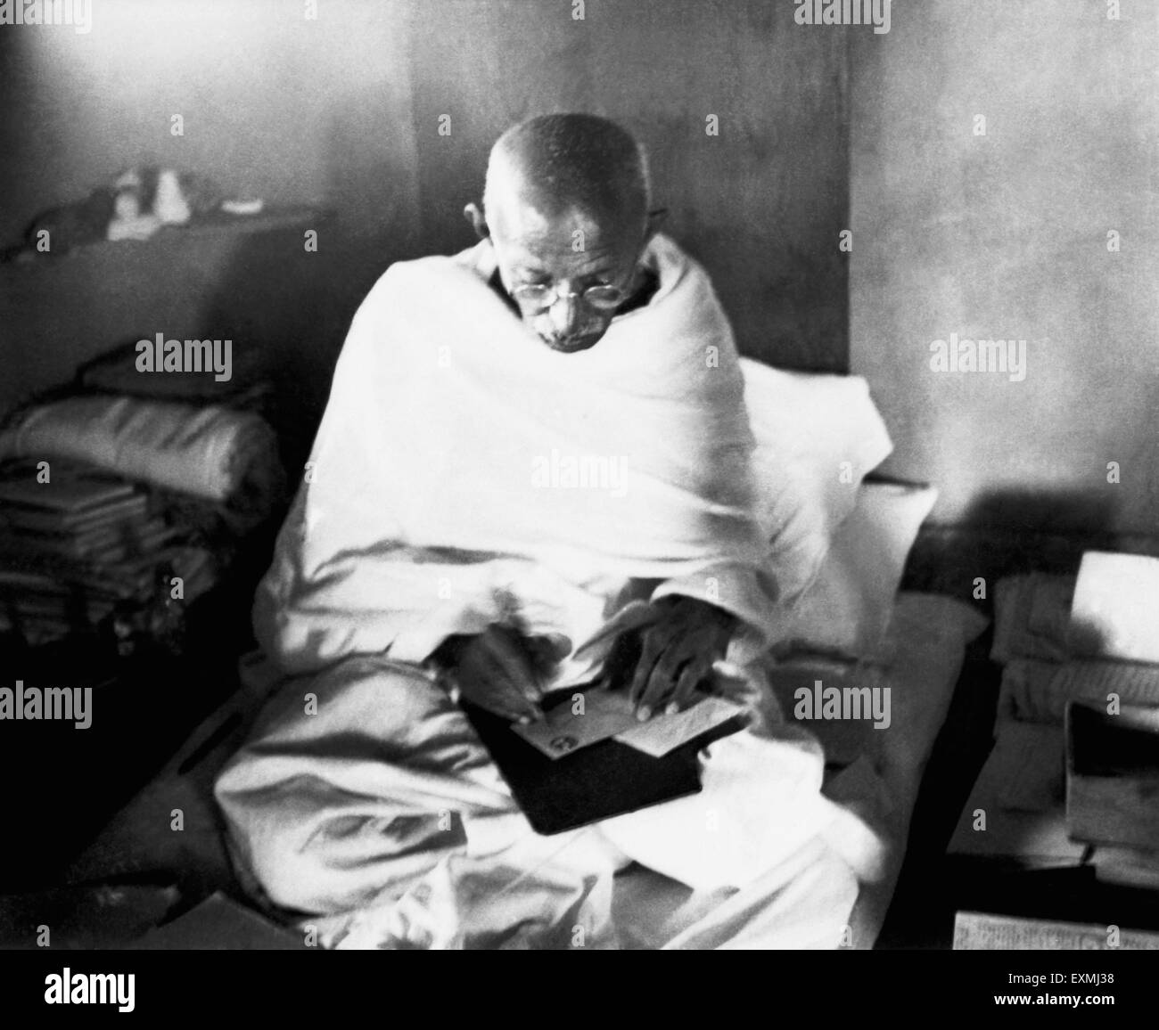 Mahatma Gandhi writing an address on an envelope in his hut at Sevagram Ashram ; 1944 NO MR Stock Photo