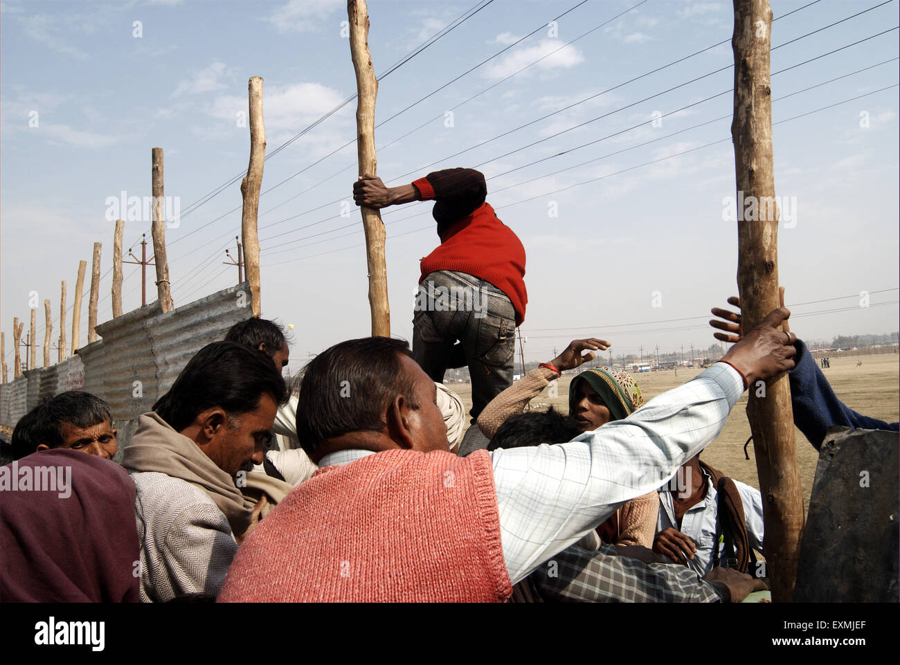 Pilgrims jumping over fence ; Ardh Kumbh Mela ; Kumbh Mela ; Kumbha Fair ; Sangam ; Allahabad ; Ilahabad ; Prayagraj ; Uttar Pradesh ; India ; Asia Stock Photo