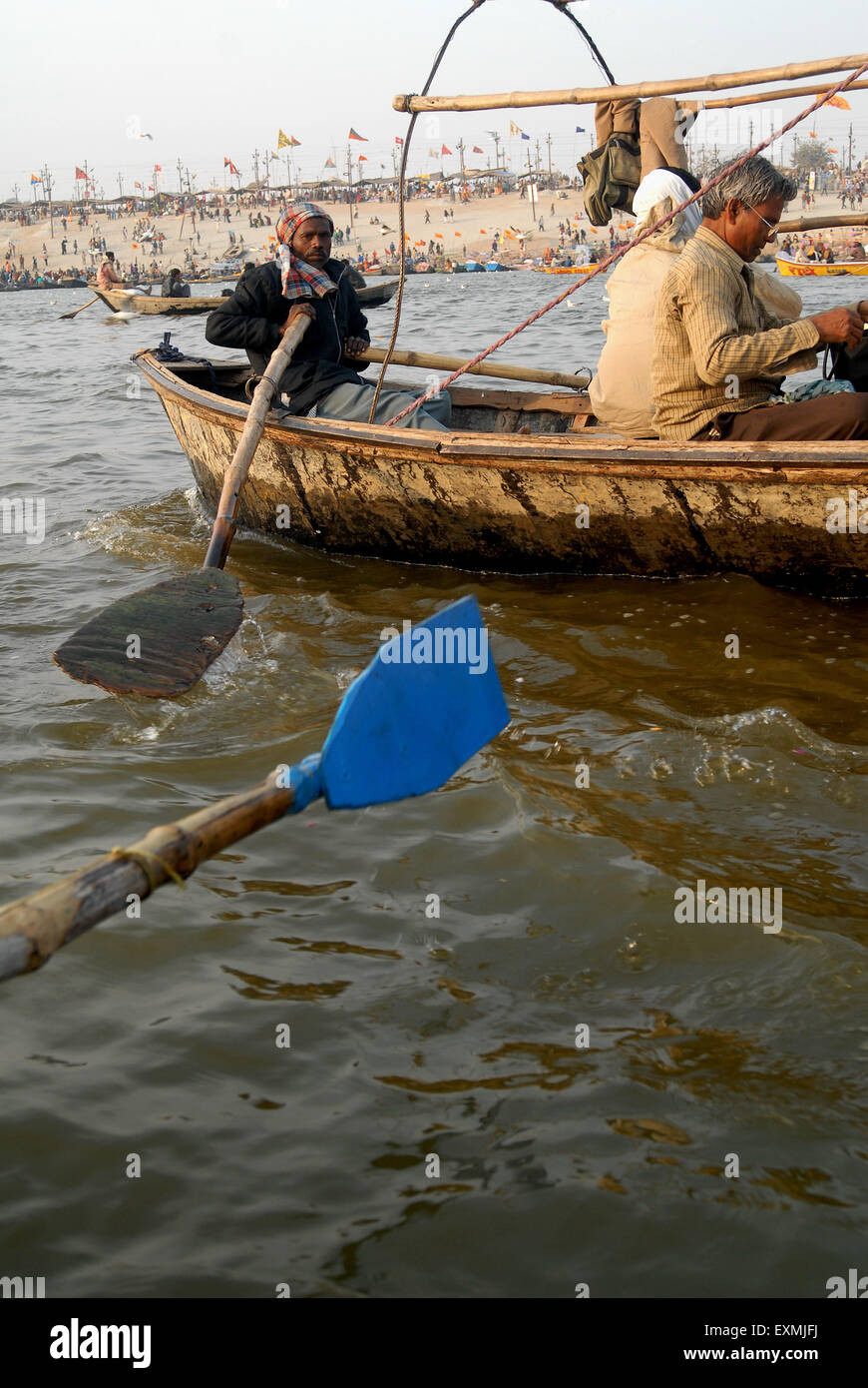 Devotees sit in boat arriving at confluence of Ganges; Yamuna and Saraswati rivers to take holy dip Ardh Kumbh Mela Allahabad Stock Photo