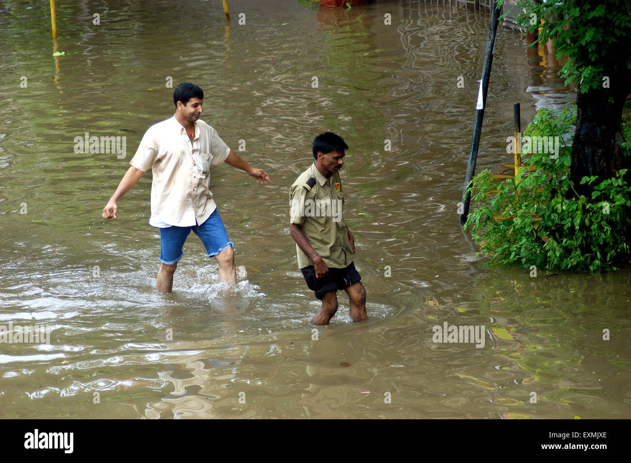 Monsoon rain floods, men walking flooded street, Bombay, Mumbai, Maharashtra, India, Asia Stock Photo