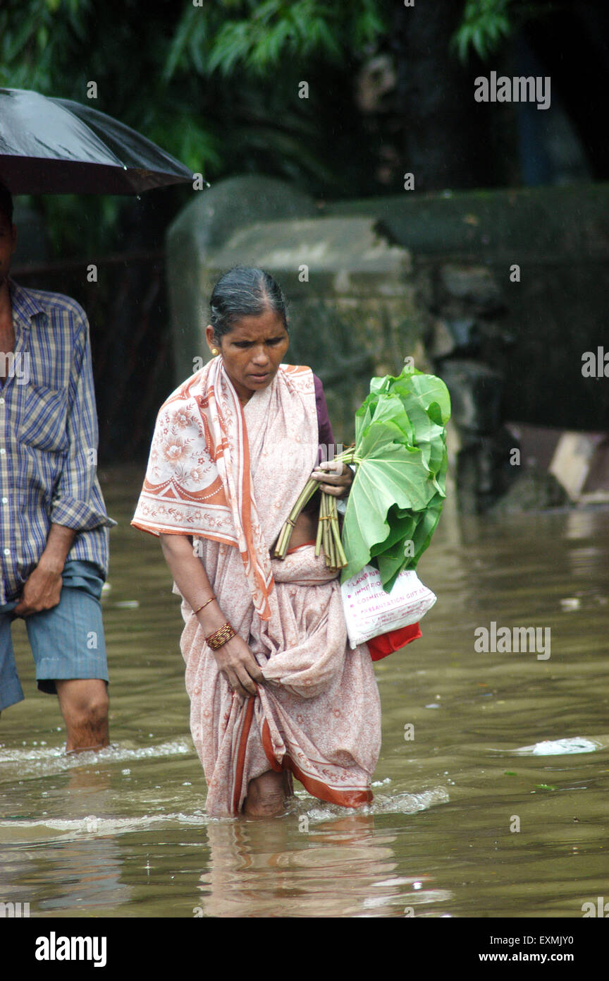 Monsoon rain floods, woman walking flooded street, Bombay, Mumbai, Maharashtra, India, Asia Stock Photo