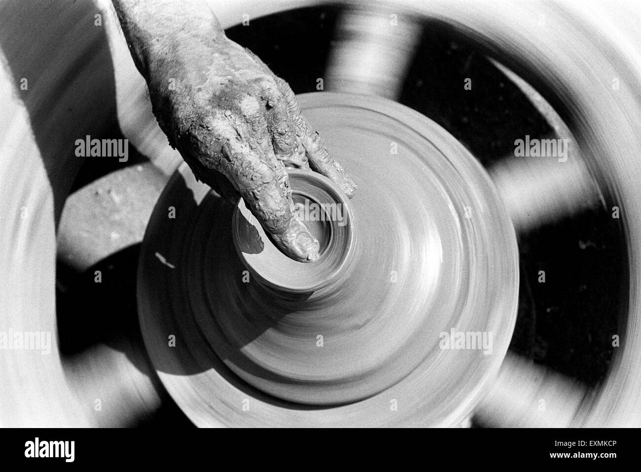 A potter sits on his potter's wheel as he makes diyas made out of clay for the Diwali festival in Kumbhaewada ; Dharavi Mumbai Stock Photo