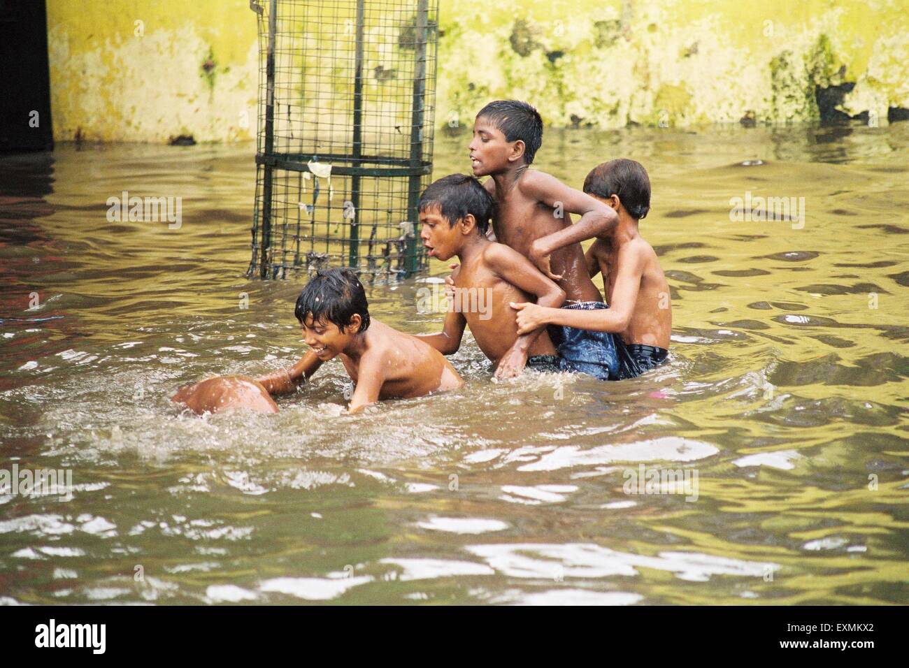 Street children enjoy in the flooded waters due to heavy rains at Chembur in Bombay now Mumbai ; Maharashtra ; India Stock Photo