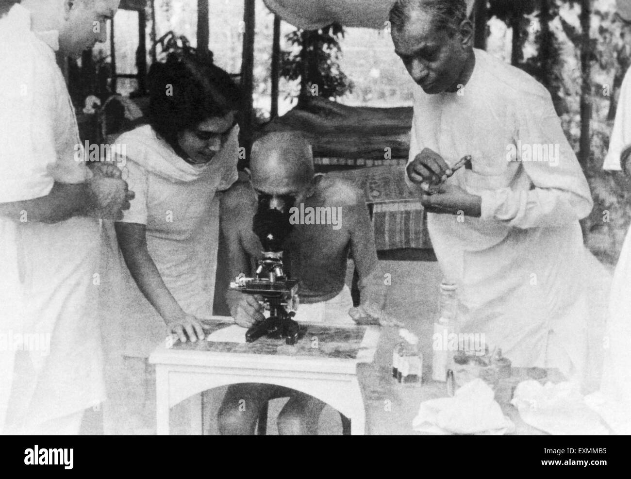 Mahatma Gandhi examining hookworm cells through a microscope at Juhu Beach bombay india  May 1944 Stock Photo