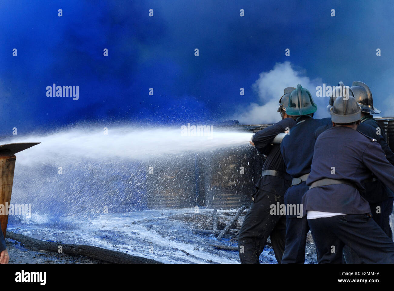 Fire brigade personnel or fire fighters trying to extinguish fire in