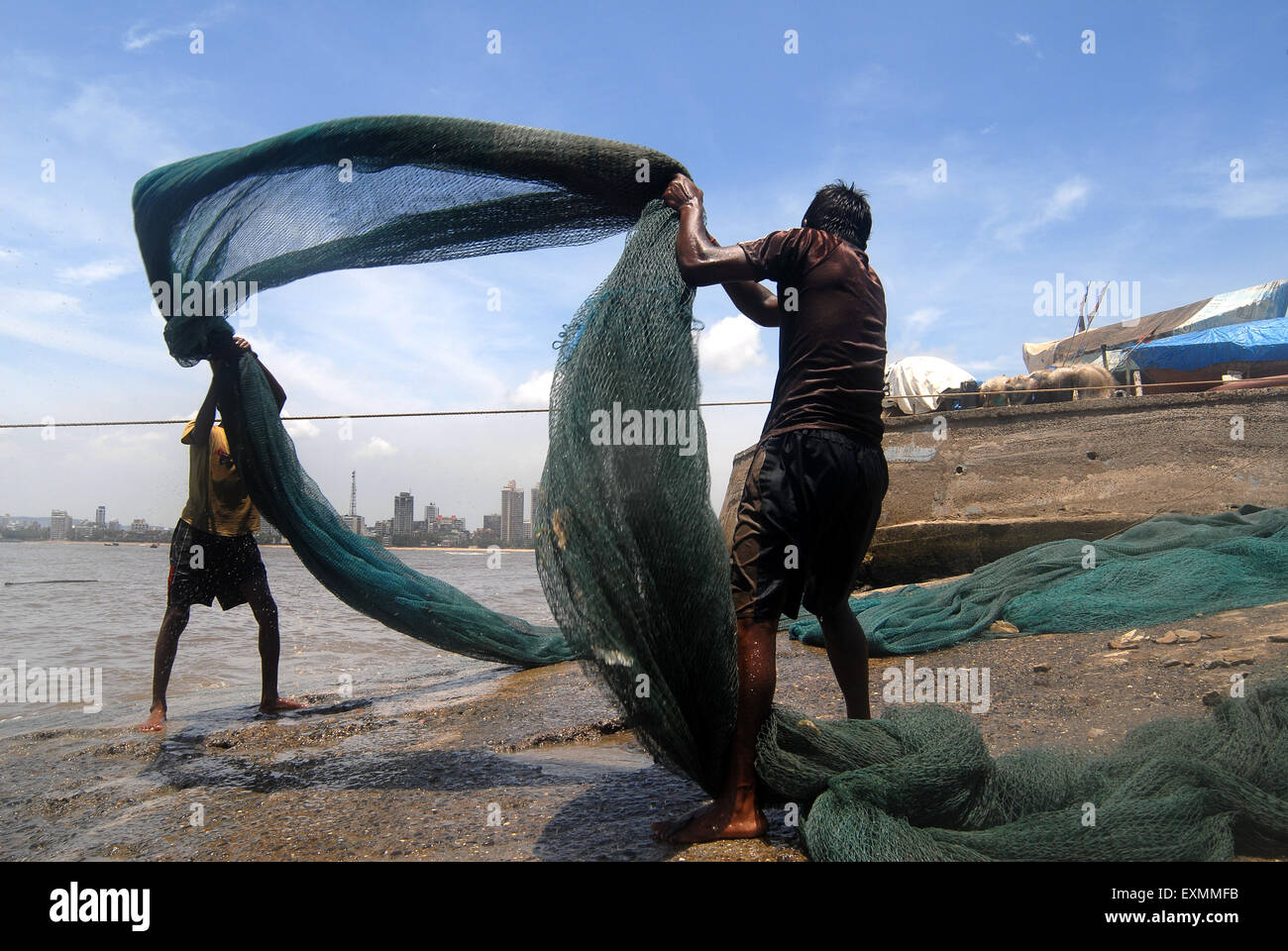 Fishermen cleaning fishing nets ; fisherman working ; Worli
