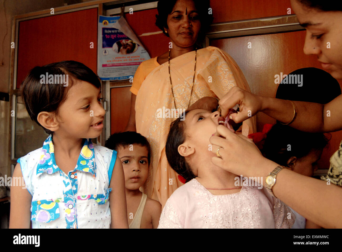 Health worker administer Polio vaccination to a child during Pulse Polio drive in Bombay now Mumbai ; Maharashtra ; India Stock Photo