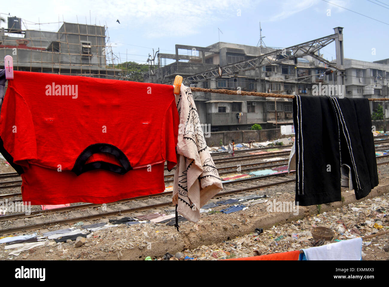 Slum dwellers living adjacent to the railway tracks hang their clothes for drying at Dharavi Mumbai Stock Photo