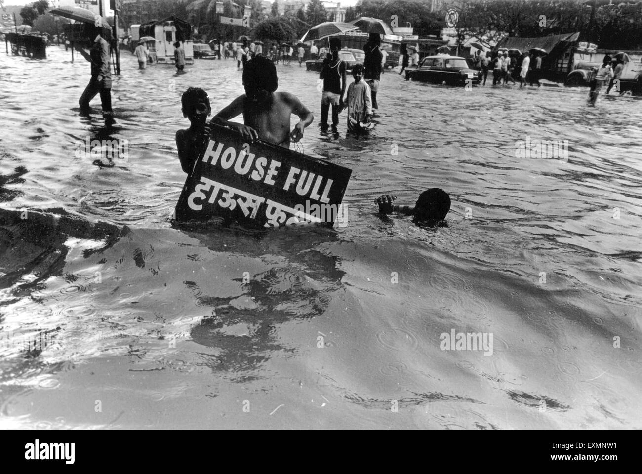 Children carrying house full board flooded roads mumbai india Stock Photo