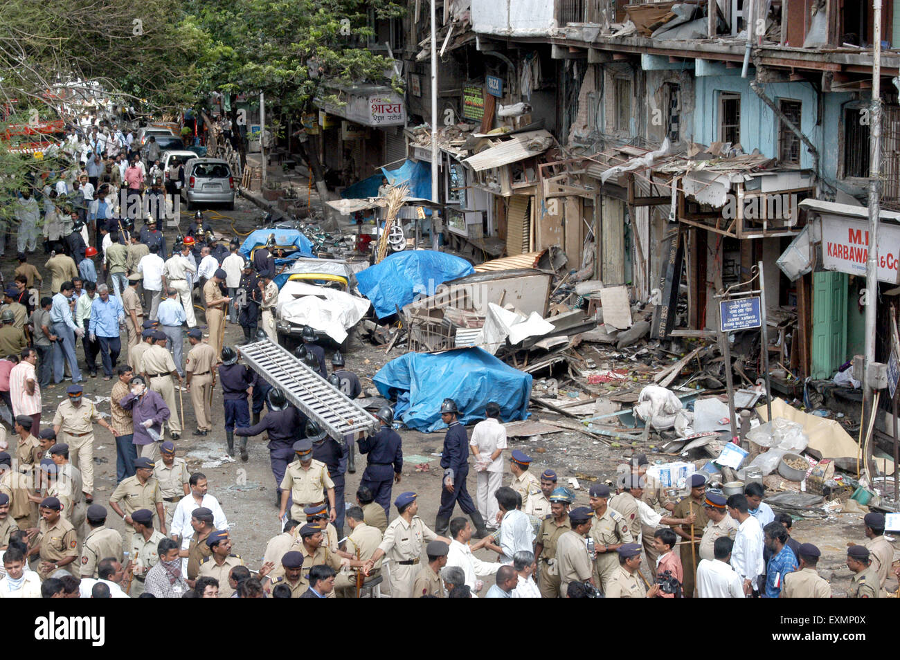 Policemen inspecting site of bomb blast also fire brigade carrying ladder at Zaveri Bazaar Kalbadevi Mumbai Maharashtra India Stock Photo