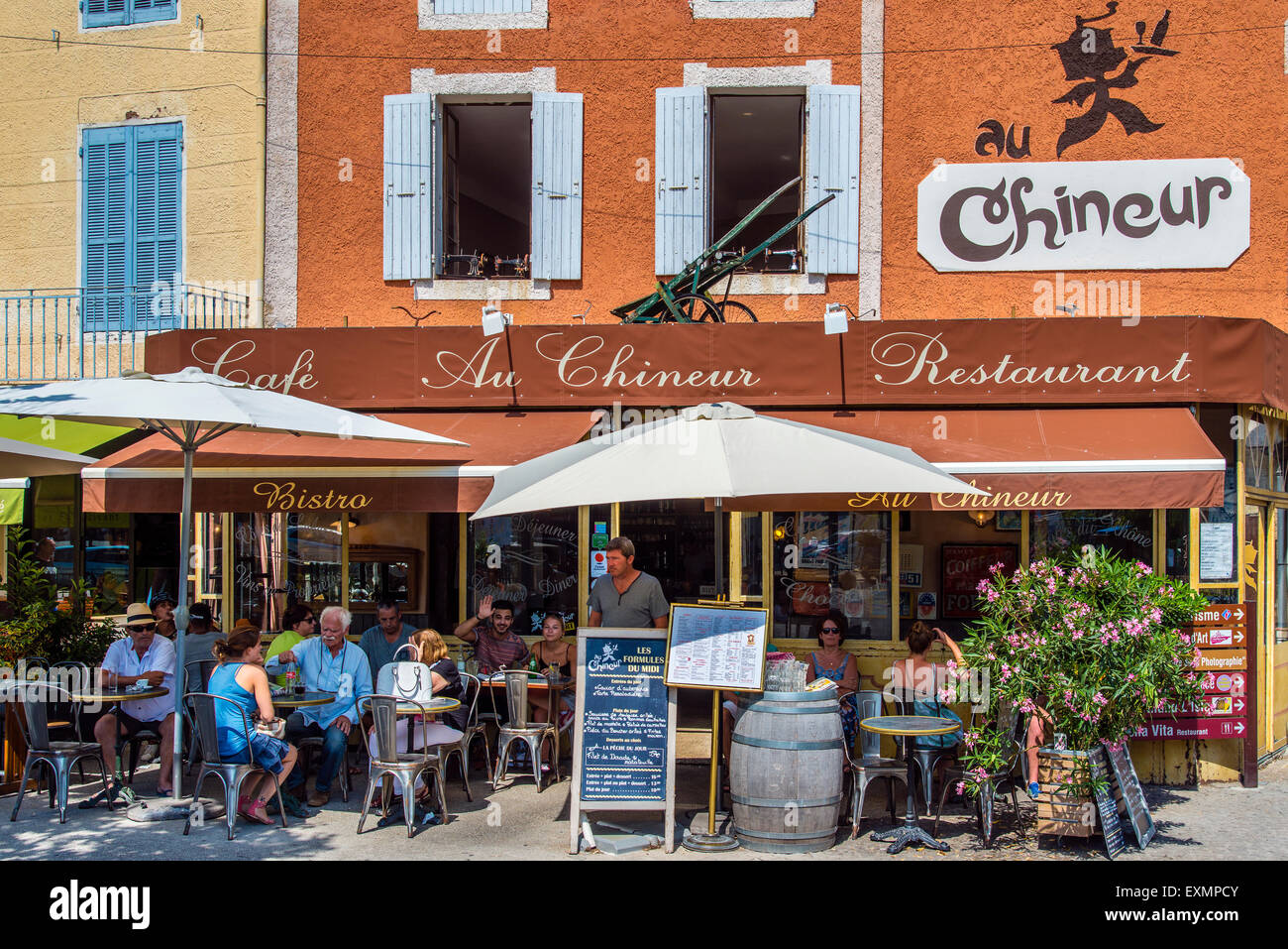 Outdoor cafe bar with people seated at tables, L’Isle-sur-la-Sorgue, Provence, France Stock Photo