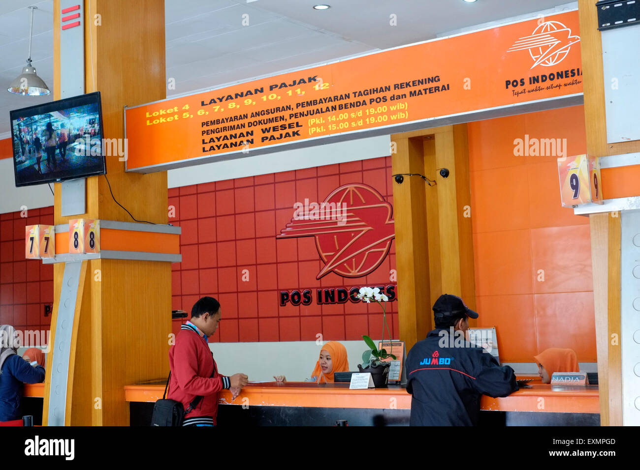 customers at a service desk at the main post office in malang java indonesia Stock Photo
