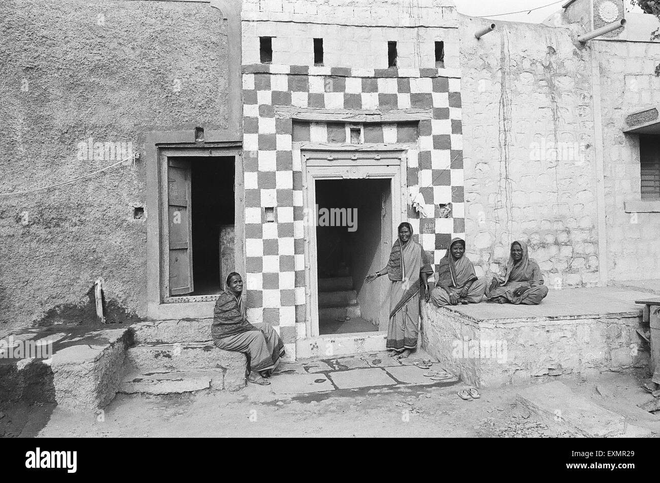 four women in front of their homes in Munagoli village in Bijapur district Karnataka India Stock Photo