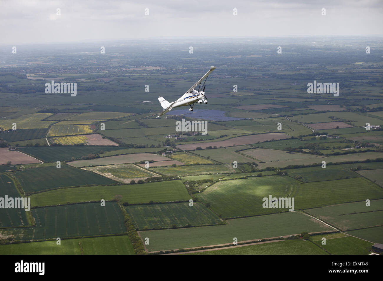 Aerial photograph of a microlight maneuver, a lightweight modern airplane, over East Sussex, and the South Downs, UK Stock Photo