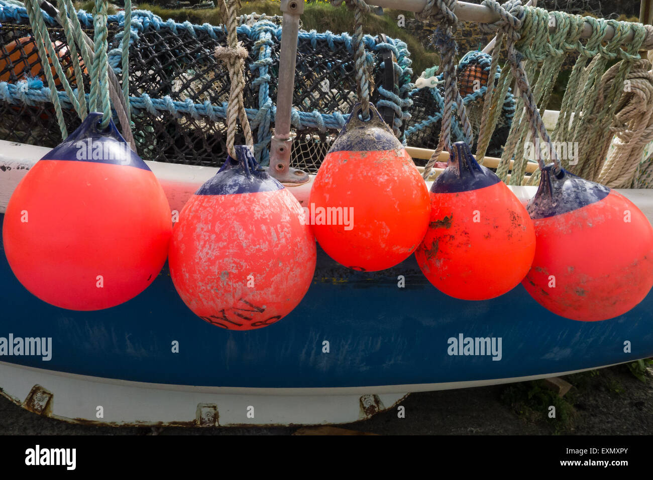 Cornwall, England. Bright red crab and lobster pot floats on a crabber boat. Stock Photo