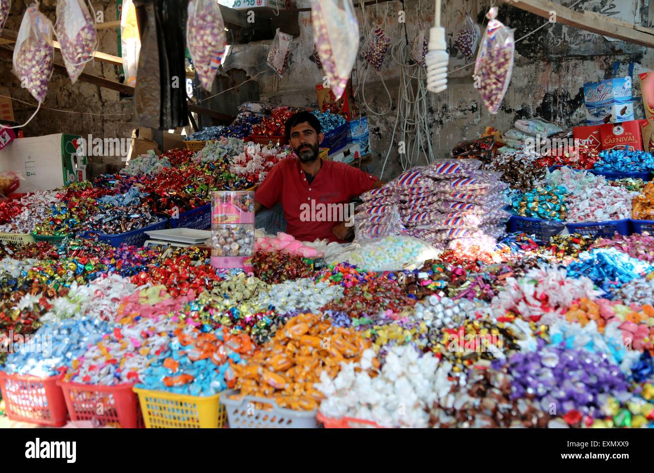 Gaza, Palestine. 15th July, 2015. Palestinians shop in a market for the Eid al-Fitr, a three-day holiday that marks the end of the fasting month of Ramadan, in Gaza city. Muslims all over the world prepare to celebrate Eid al-Fitr, starting with the with the sighting of the new moon, to mark the end of the fasting month of Ramadan. © Nidal Alwaheidi/Pacific Press/Alamy Live News Stock Photo