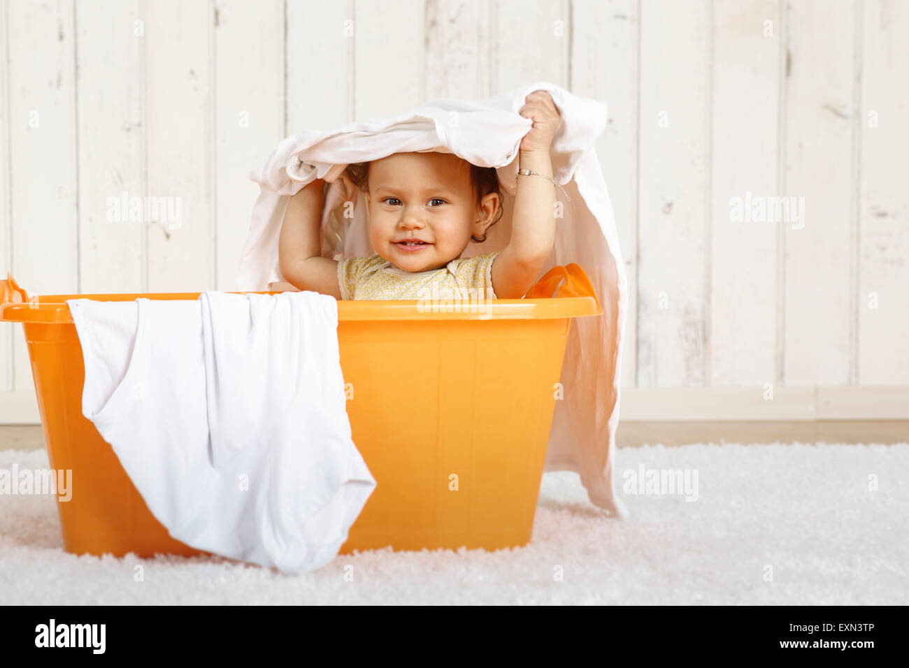 Baby girl sitting in a laundry basket Stock Photo - Alamy