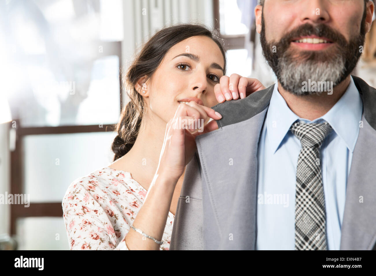 Young seamstress taking measurements for bespoke clothing Stock Photo