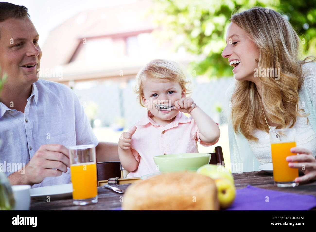 Happy family sitting at breakfast table Stock Photo - Alamy