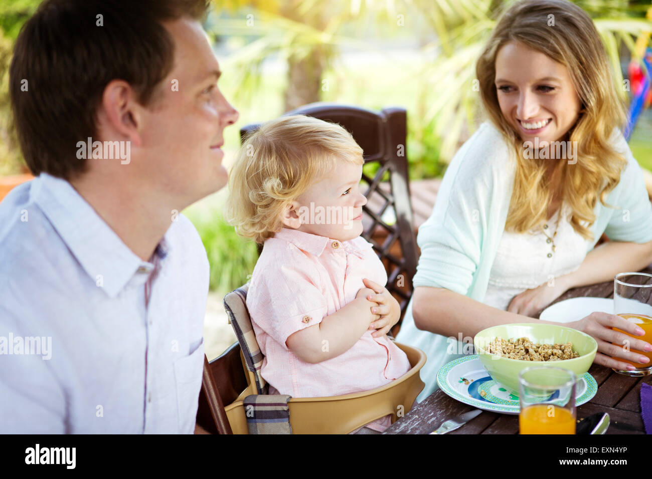 Happy family sitting at breakfast table Stock Photo - Alamy