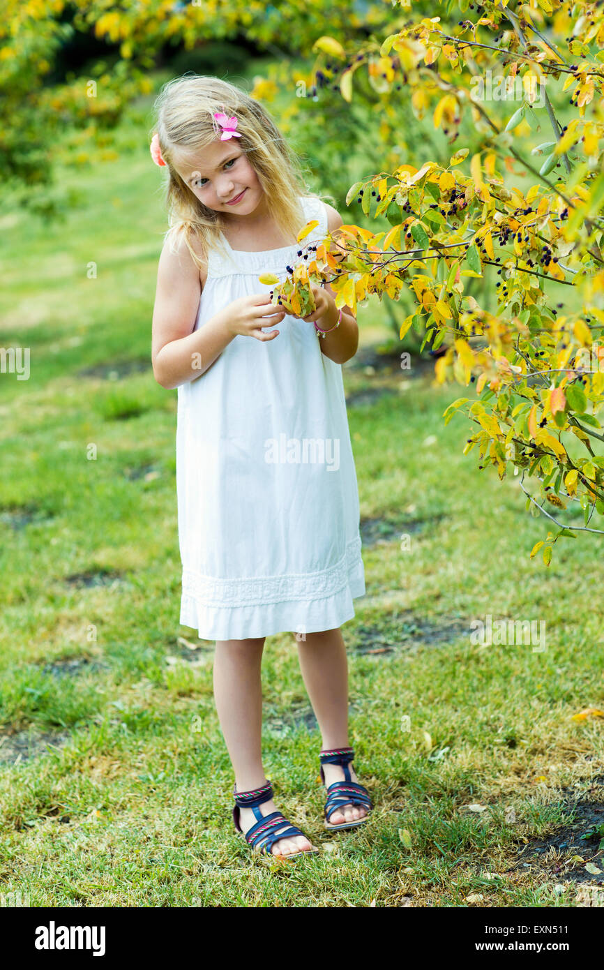 Portrait of smiling girl wearing white summer dress and flowers Stock Photo