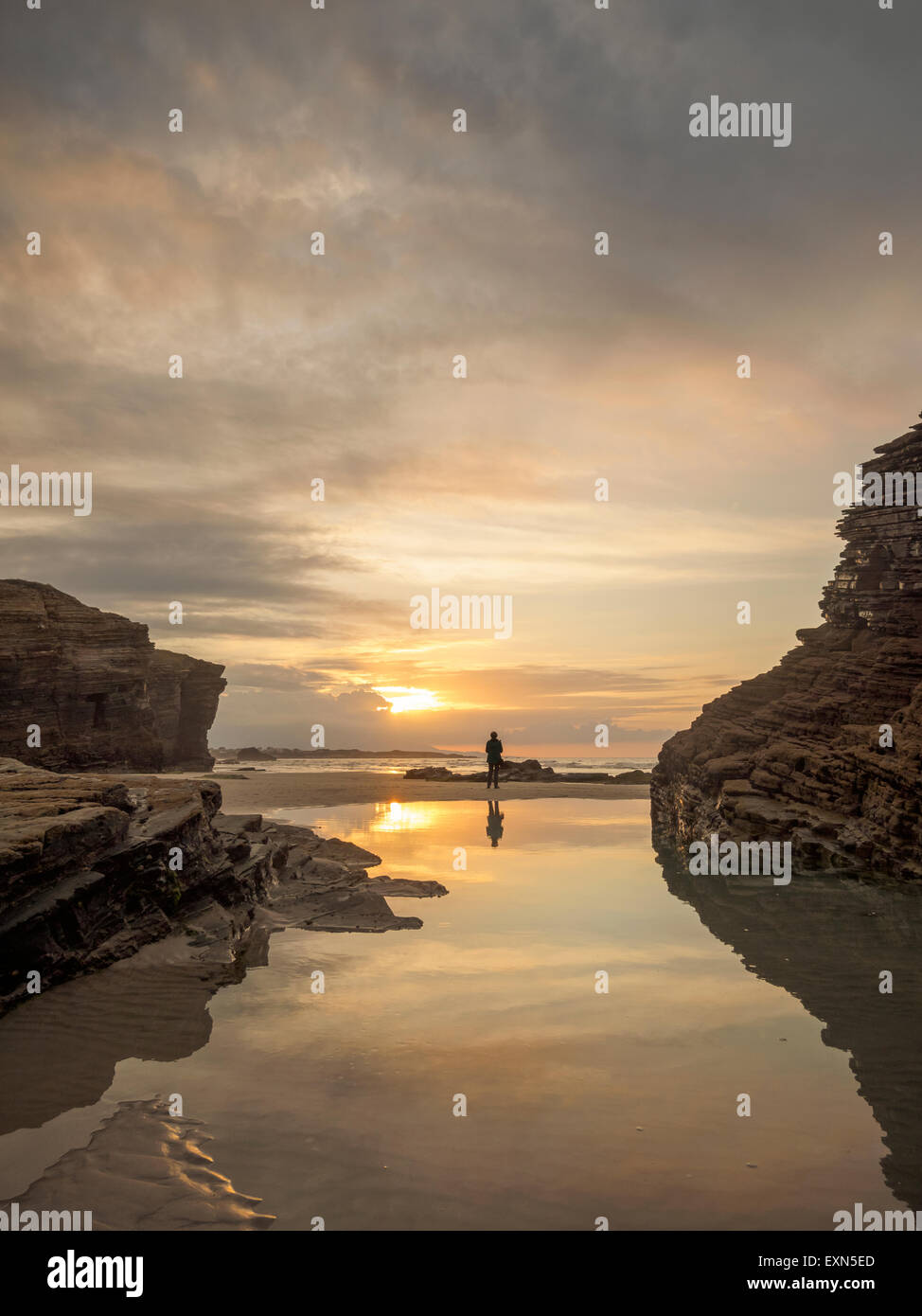 Spain, Galicia, Ribadeo, Playa de Aguas Santas at sunset, small person on the beach Stock Photo