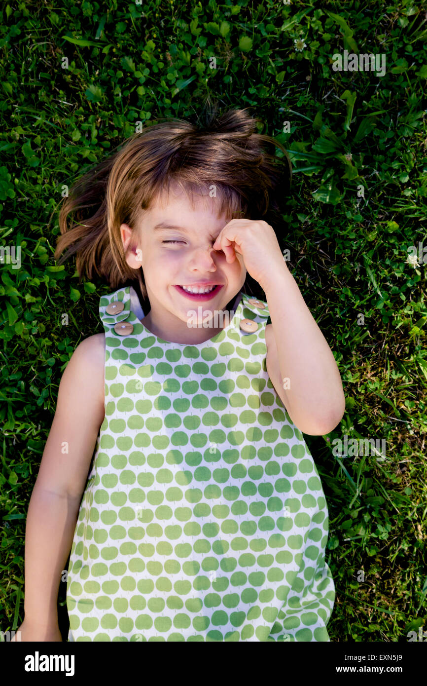 Smiling little girl with closed eyes lying on a meadow Stock Photo - Alamy