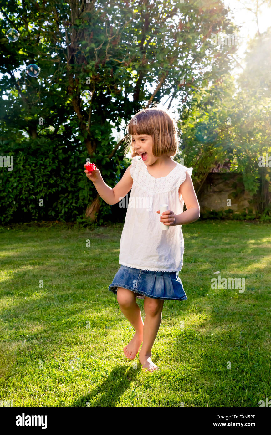 Little girl playing with soap bubbles in a garden Stock Photo - Alamy