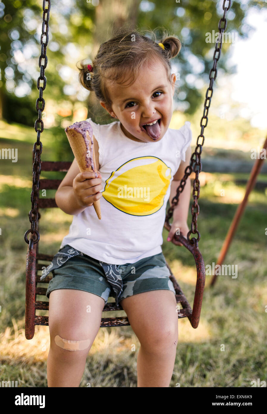 Portrait of little girl with outstretched tongue sitting 