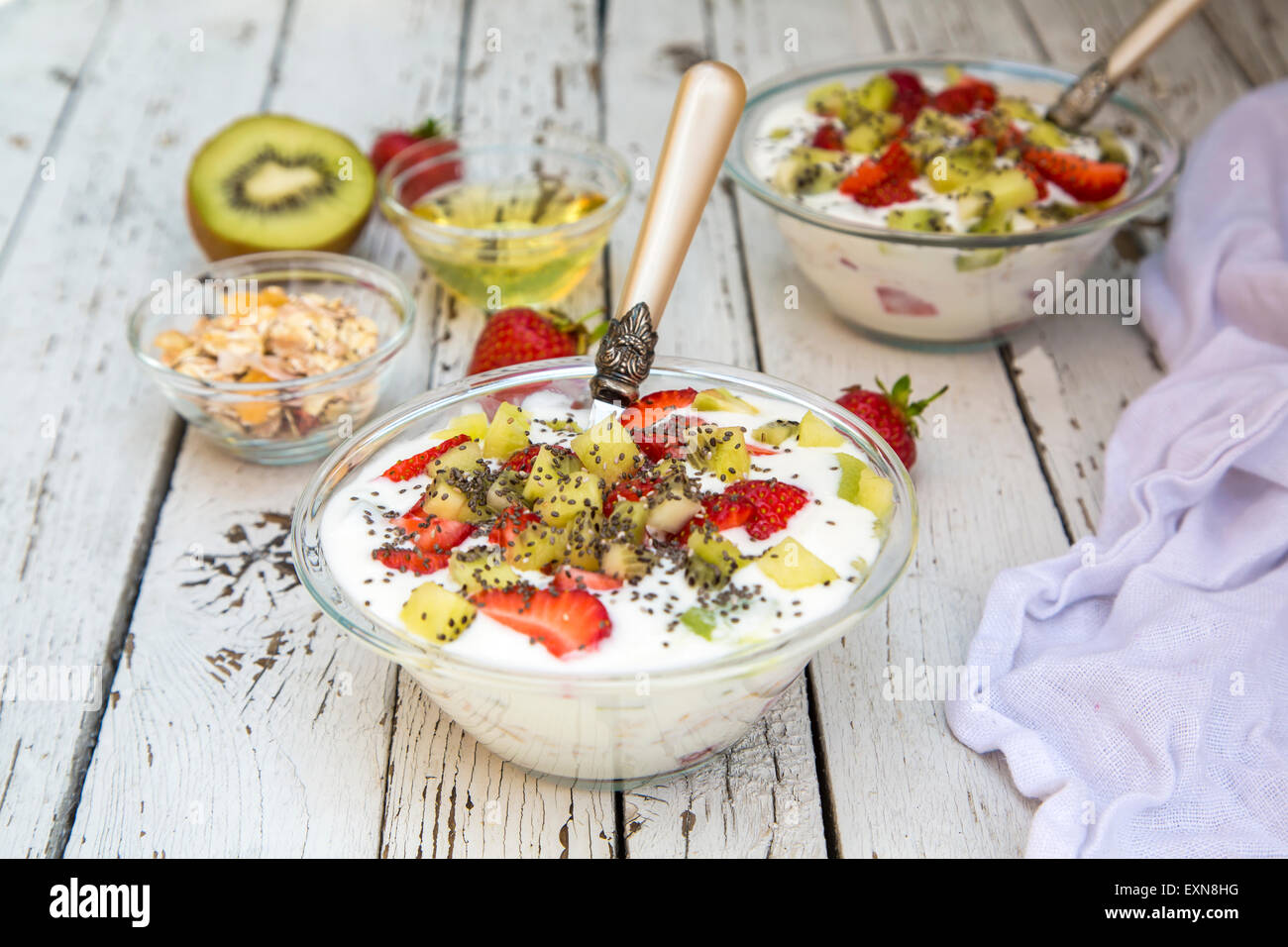 Strawberry kiwi yogurt with cereals, chia seeds, agave syrup in glass