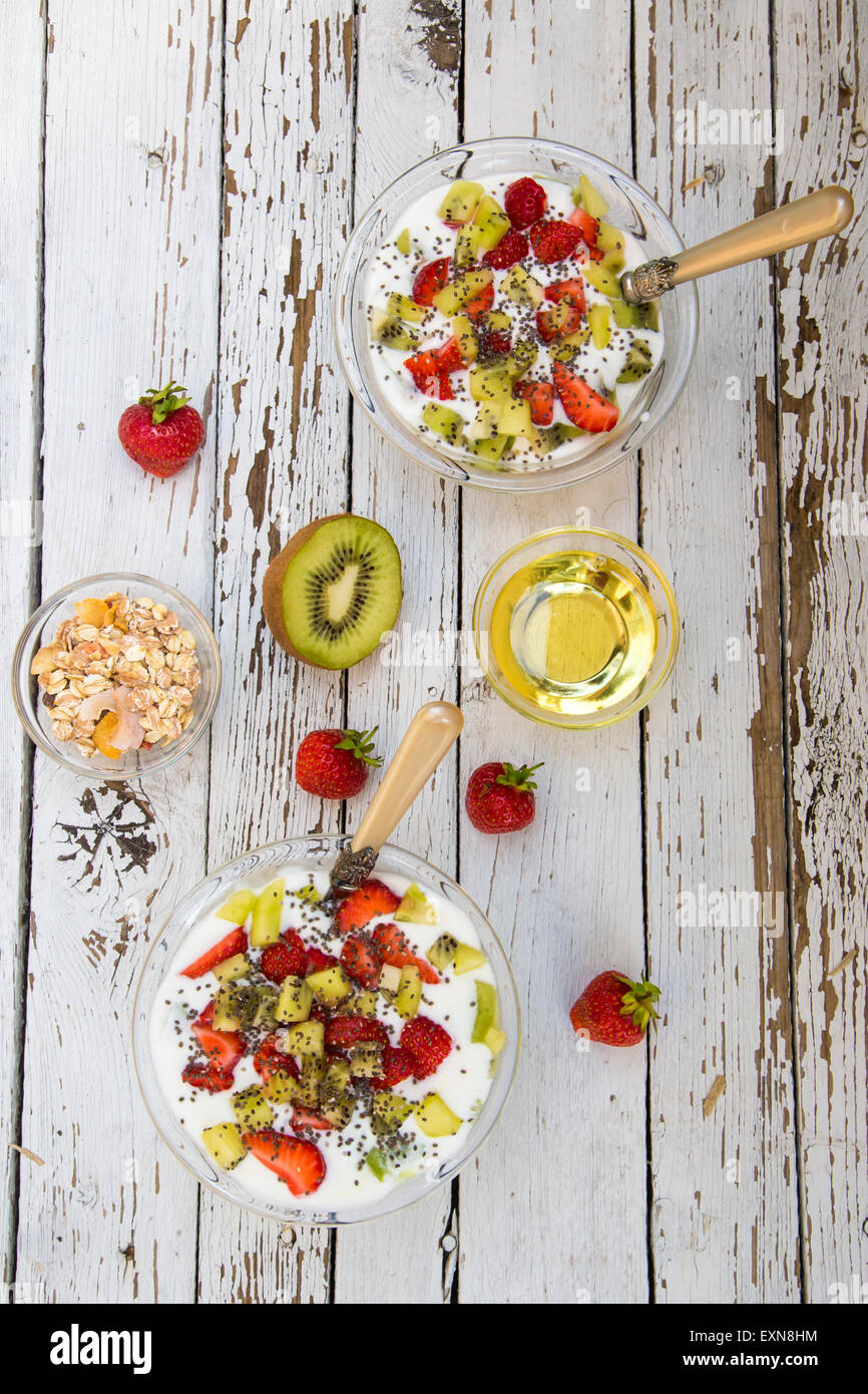 Strawberry kiwi yogurt with cereals, chia seeds, agave syrup in glass