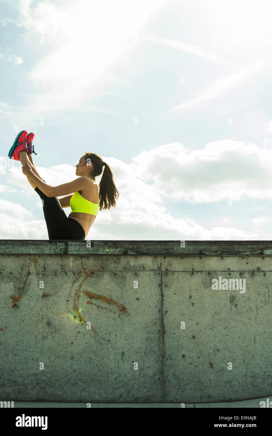 Young woman doing stretching exercises on a wall Stock Photo - Alamy