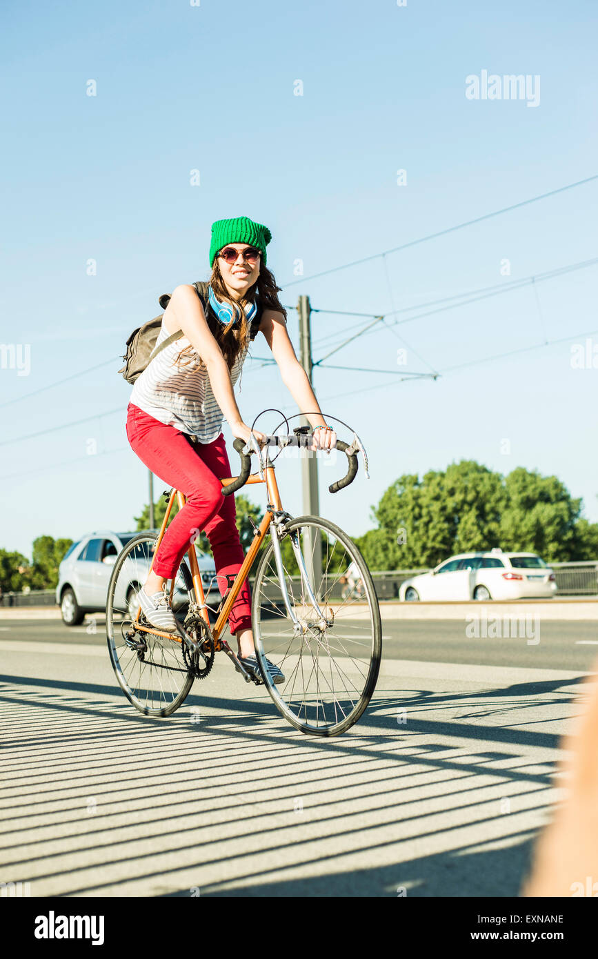 Young woman riding bicycle on pavement at the street Stock Photo - Alamy