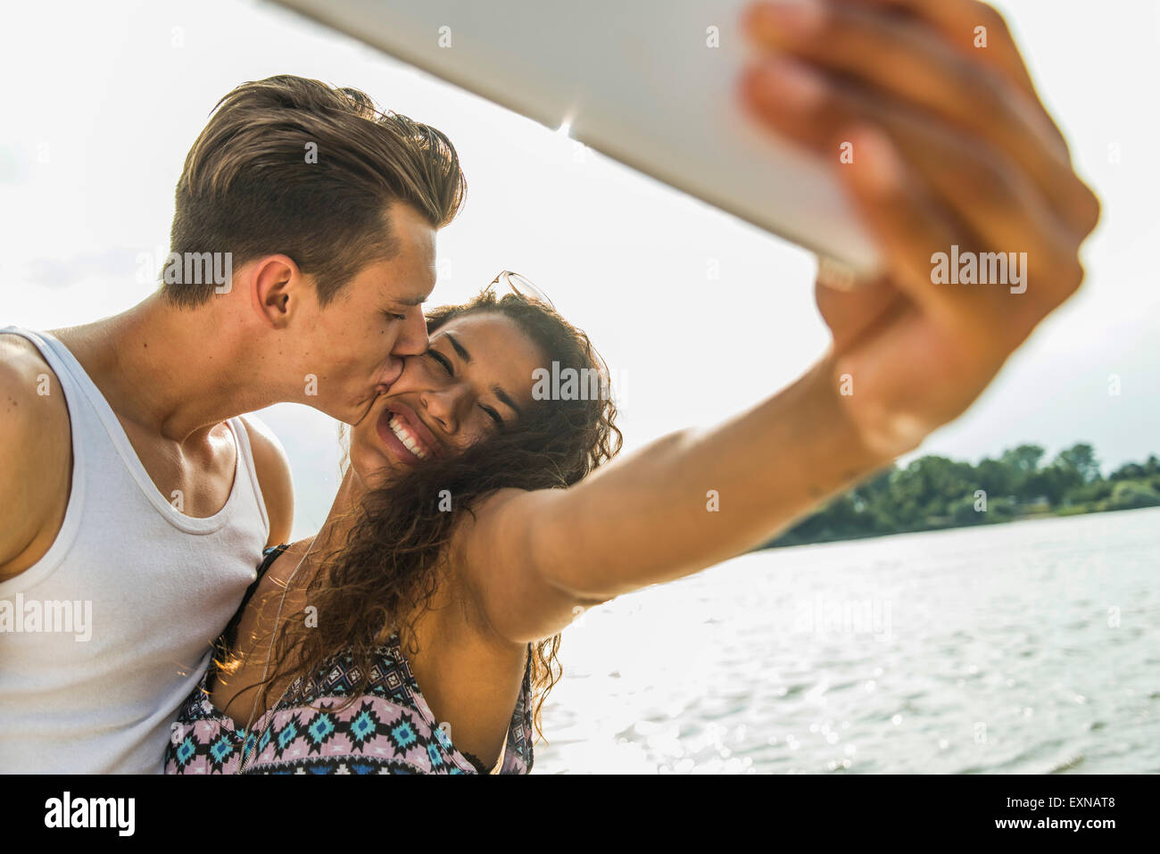 Happy young couple taking a selfie by the riverside Stock Photo - Alamy