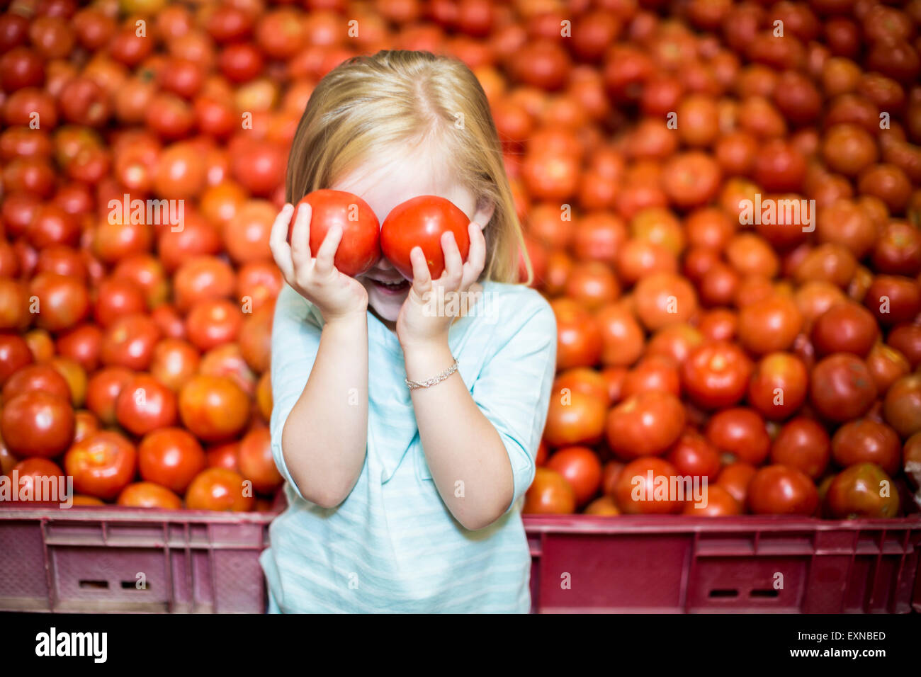 Little girl in front of tomato stall covering eyes with tomatoes Stock ...