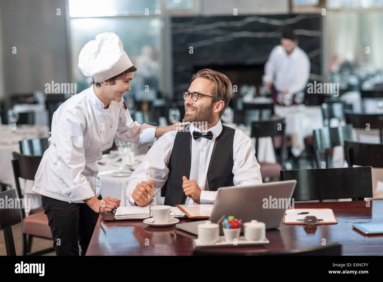 Restaurant chef and manager discussing reservations Stock Photo