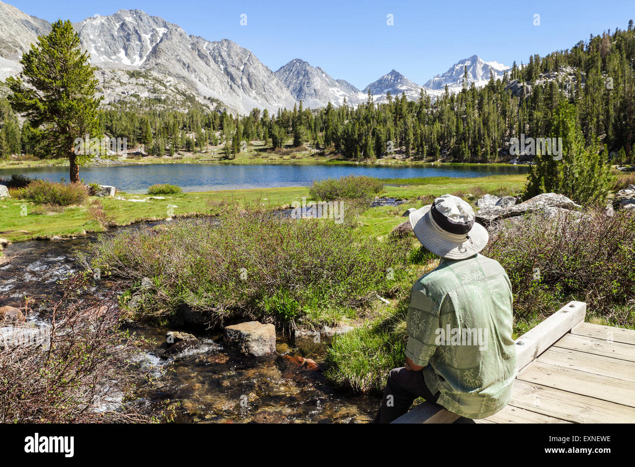 Resting hiker admires view in Little Lakes Valley in Rock Creek Canyon in the Eastern Sierra in Northern California Stock Photo