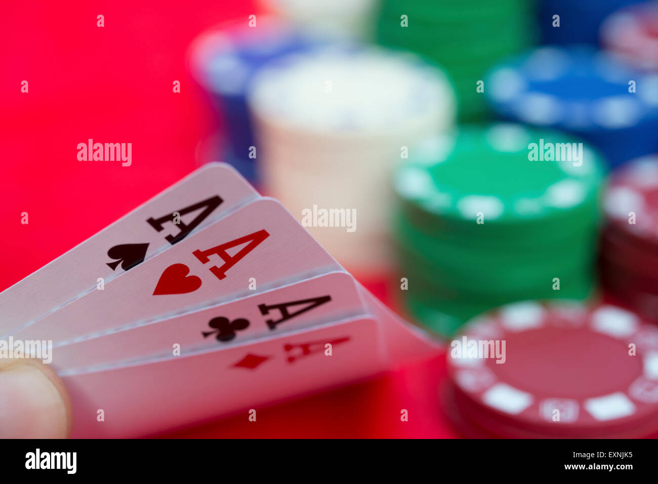 poker player holding 4 Ace of pokers beside lots of chips Stock Photo