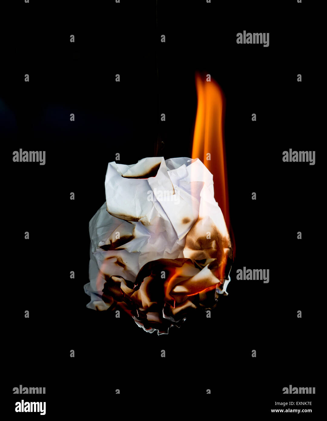 white crumpled  paper burning on black background Stock Photo
