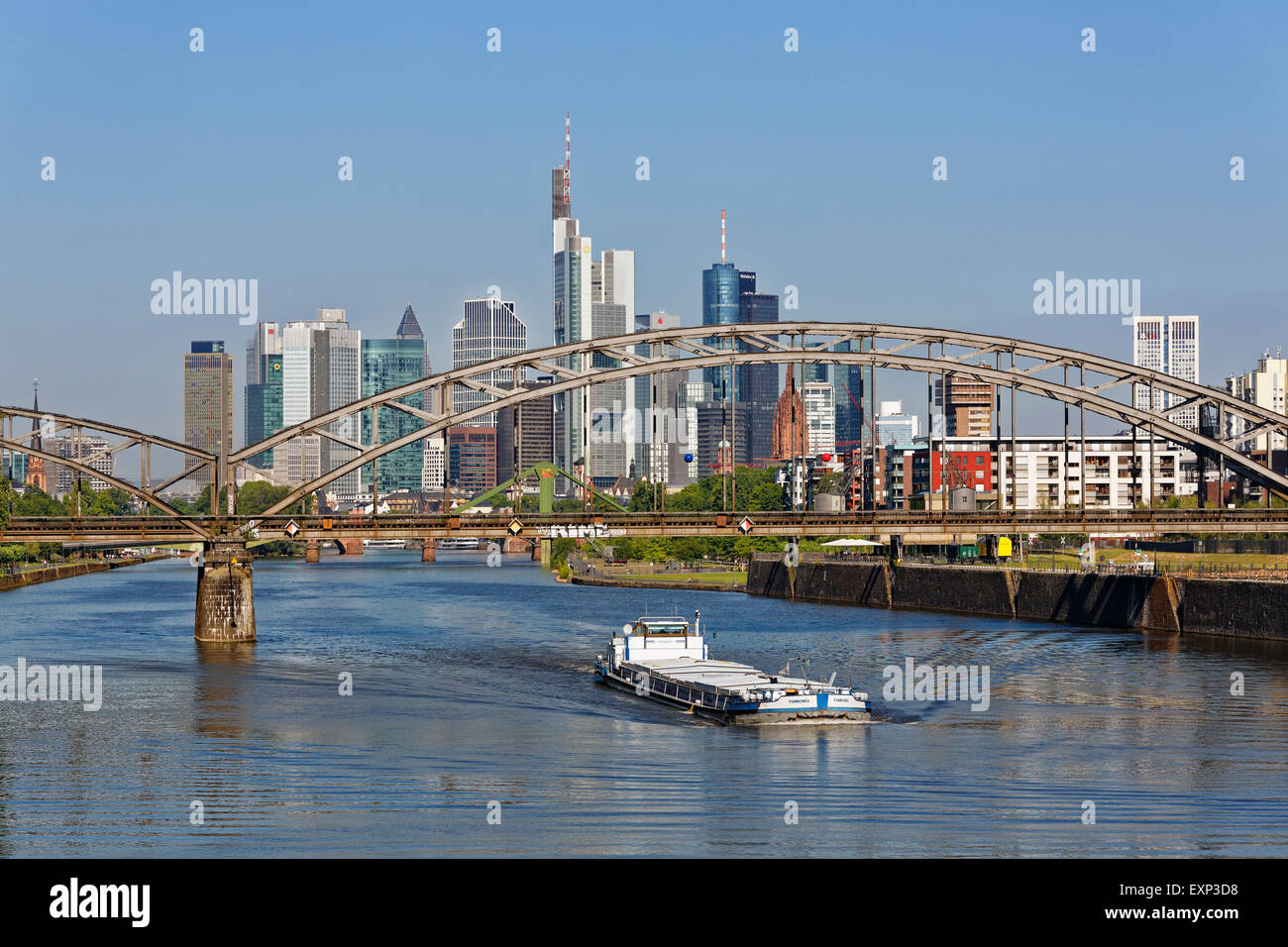Freighter on River Main beneath Deutschherrnbrücke and skyline, Frankfurt am Main, Hesse, Germany Stock Photo