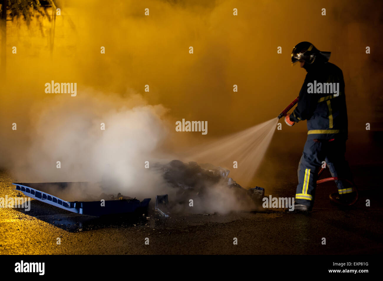 Athens, Greece. 15th July, 2015. Fireman distinguish damage caused by Anarchists during the Anti austerity protests in Athens while the 3rd Bailout vote is discussed in the Greek Parliament. Credit:  Martin Garnham/Alamy Live News Stock Photo