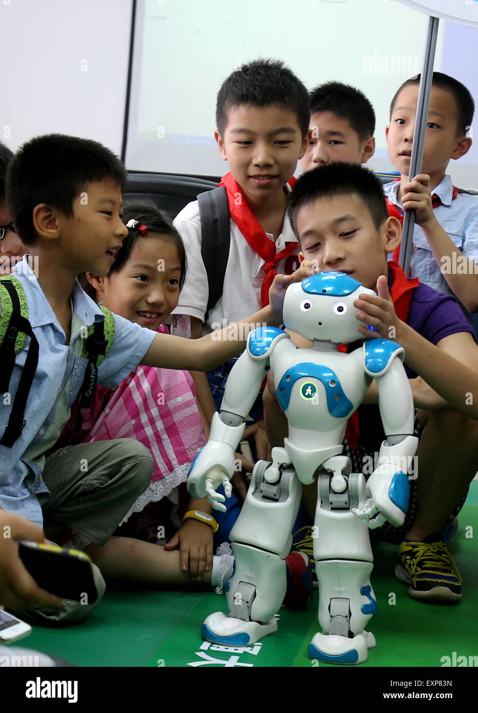 Shanghai, China. 16th July, 2015. Children interested in scientific invention meet Robot Nao at a robot laboratory in Shanghai Jiaotong University, east China, July 16, 2015. Nao is a 58-centimeter tall robot developed and manufactured by Aldebaran Robotics, a Paris-based company. Credit:  Liu Ying/Xinhua/Alamy Live News Stock Photo