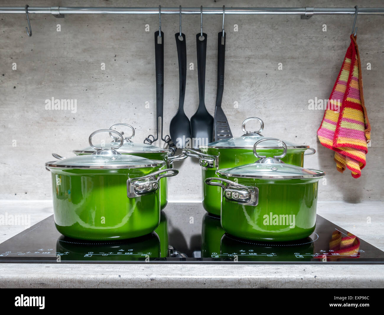 Four green enamel stewpots on black induction cooker Stock Photo Alamy