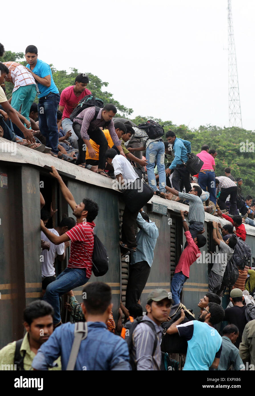 Dhaka, Bangladesh. 16th July, 2015. Bangladeshi passengers sit on the roof of a train, as they head to their homes to celebrate Eid al-Fitr in Dhaka, Bangladesh, Thursday, July 16, 2015. Hundreds of thousands of people working in Dhaka plan to leave for their home towns to celebrate with their family the upcoming Eid al-Fitr. Stock Photo