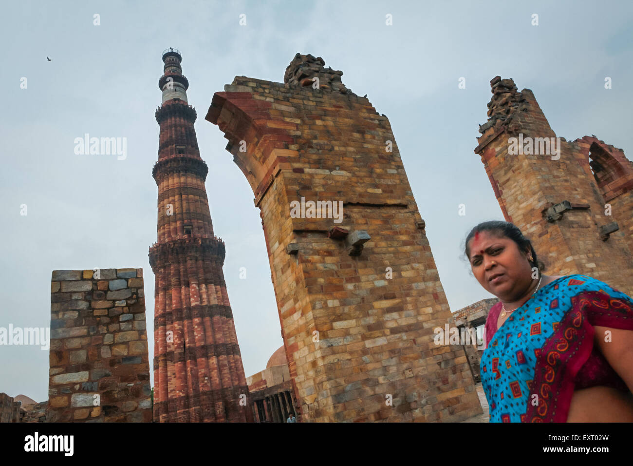 A woman visitor is photographed in a background of Qutab Minar in Mehrauli, South Delhi, Delhi, India. Stock Photo