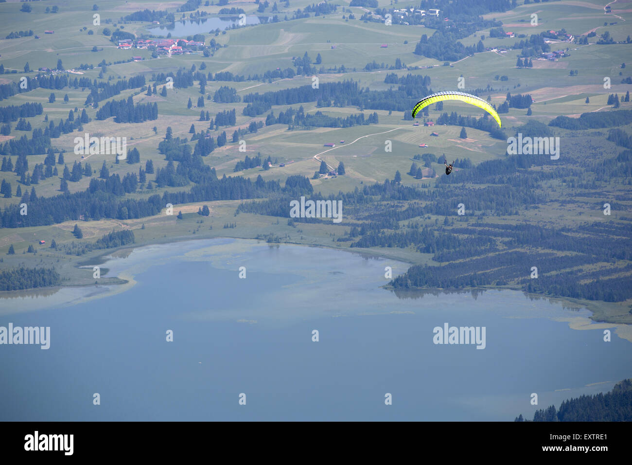 Paraglider flying over Bavarian lake Forggensee Stock Photo