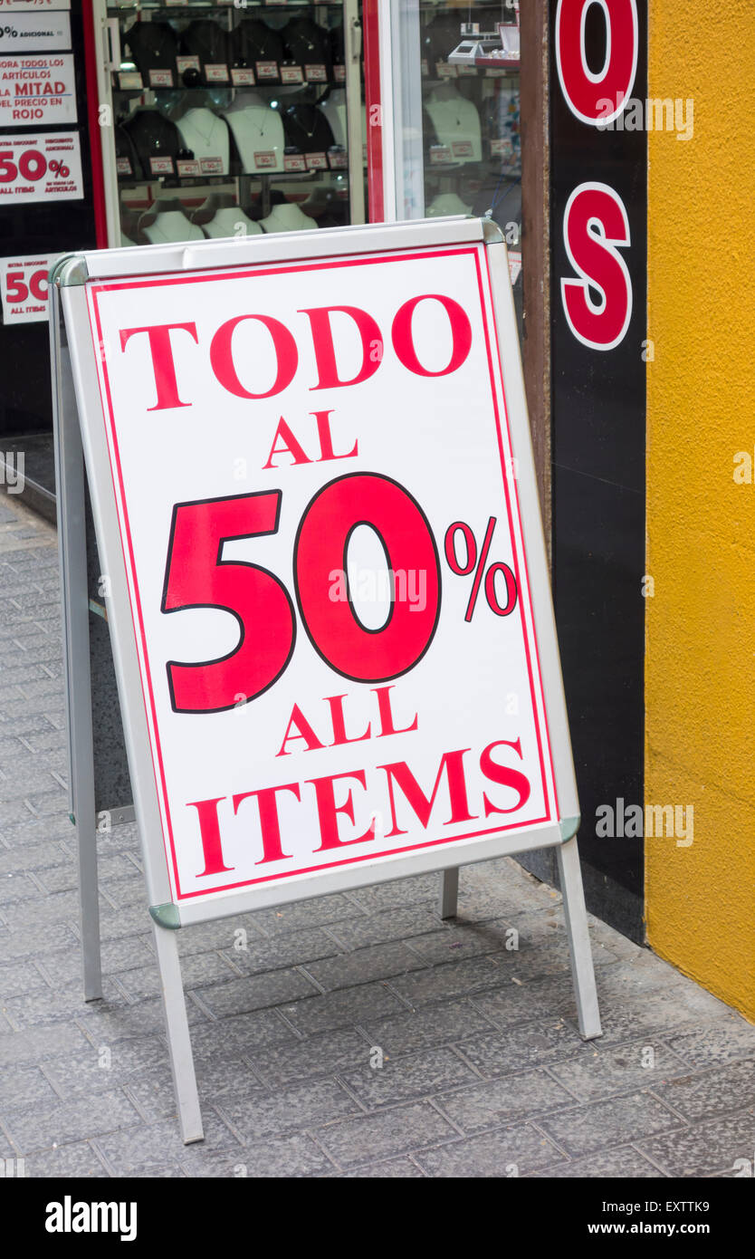 Discount sign in Spanish and English outside shop in Spain Stock Photo
